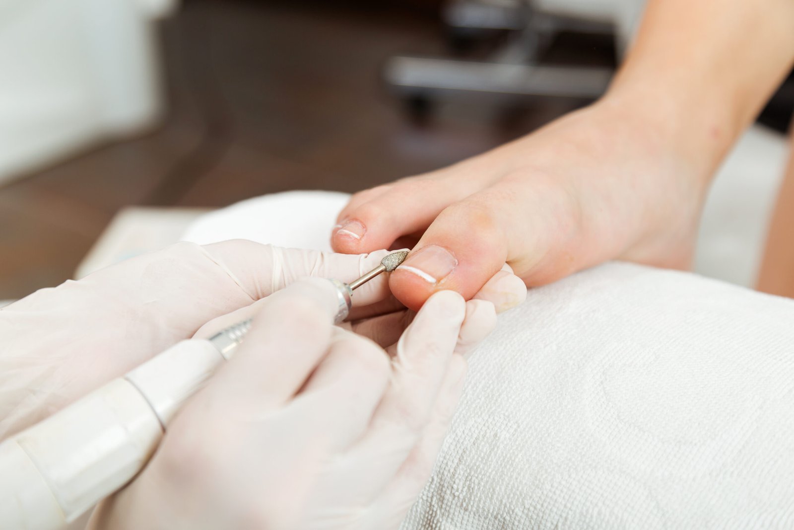 Portrait of young woman doing pedicure in salon. Beauty concept.